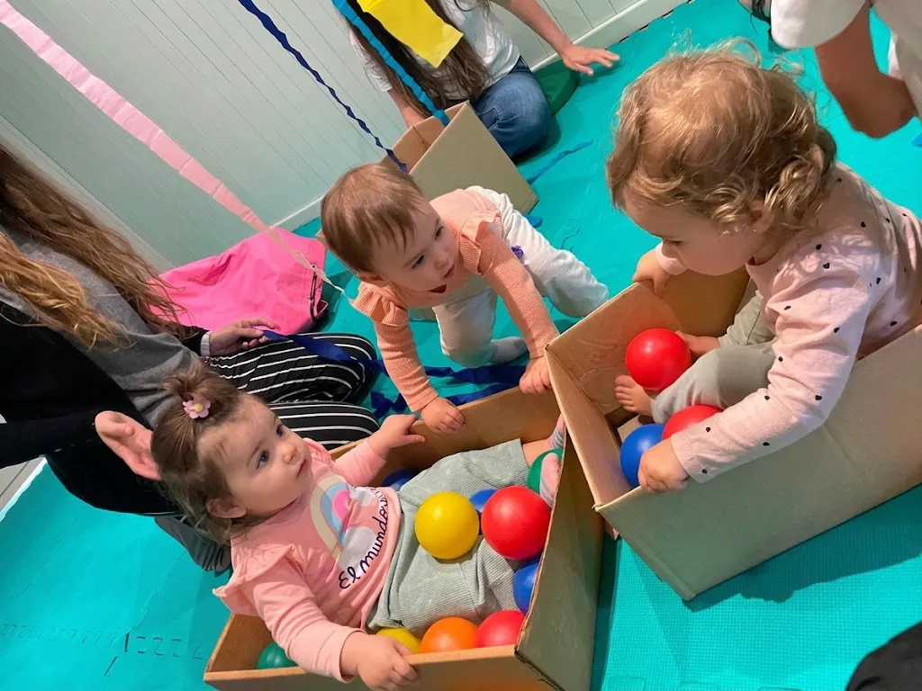 Bebes jugando adentro de cajas con pelotitas de colores